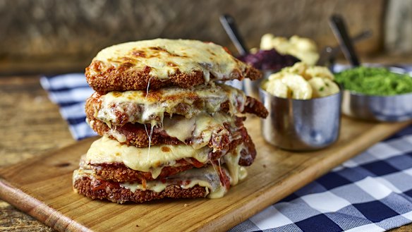 Meet the Schnitzelmeister. It’s a six-stack, chicken schnitzel tower topped with Napoli sauce, ham and cheese and served with four side dishes.
