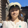 Thunberg with a sign reading in Swedish “School strike for the Climate” while wearing the cap in Stockholm on Friday that high school students typically wear in Sweden upon graduation.