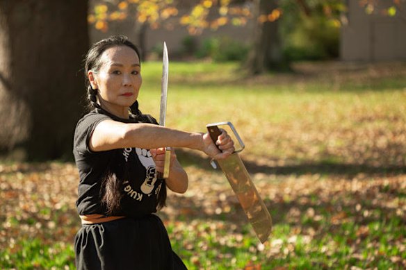 Anne Pang with martial arts weapons in Canterbury Gardens, Canterbury, in 2021.
