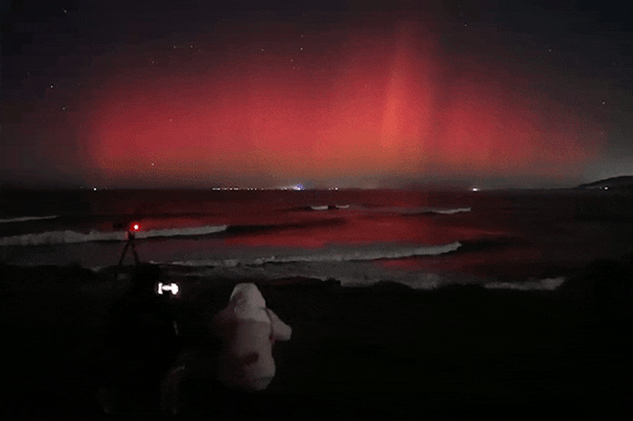 The aurora australis lights up the sky off Gerroa with magenta and beams of orange.