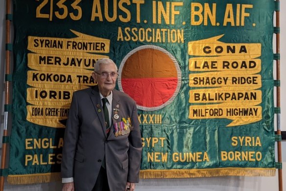 Les Thomson with the 2/33 Australian Infantry Batallion banner in 2023.