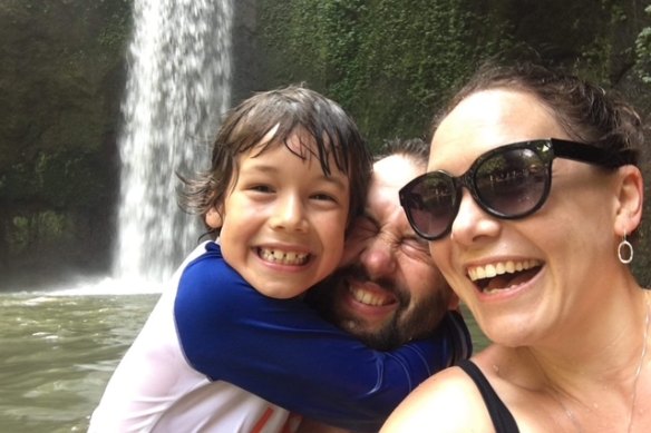 The author enjoying a dip with his family, in the pool below a waterfall in Bali.