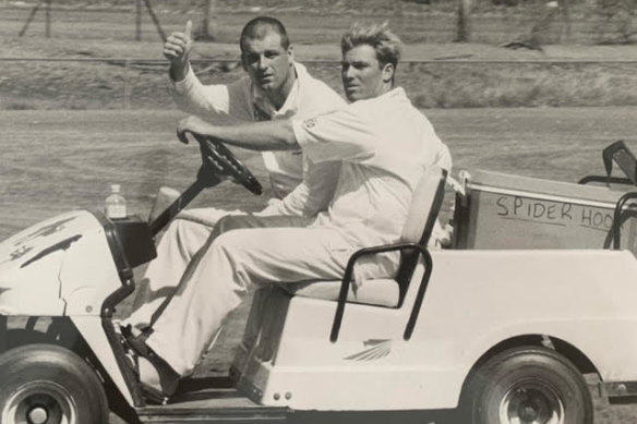 Warne steers the drinks cart with Berry on board.