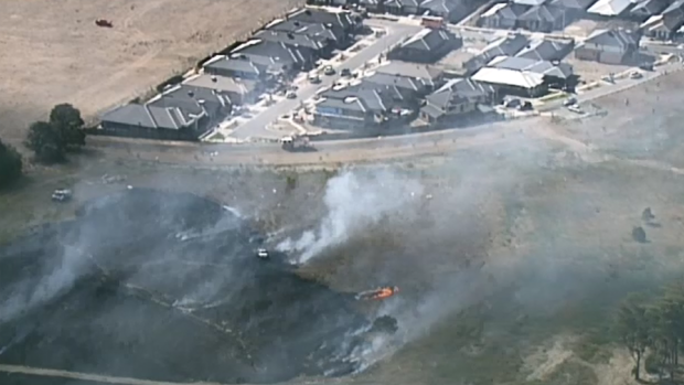 The grassfire is burning close to homes. 
