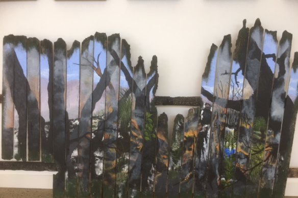 Images from a burnt fence are part of the art exhibition in Mallacoota, a year after the fires.