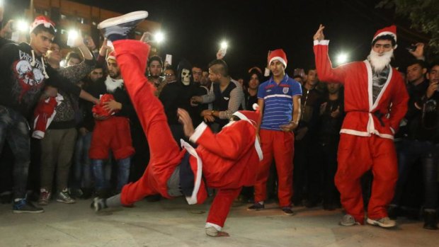 Acrobatic performers, dressed in Santa Claus costumes in Iraq.