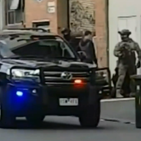 Footage shows a heavily armed officer wearing camouflage take part in the arrest.