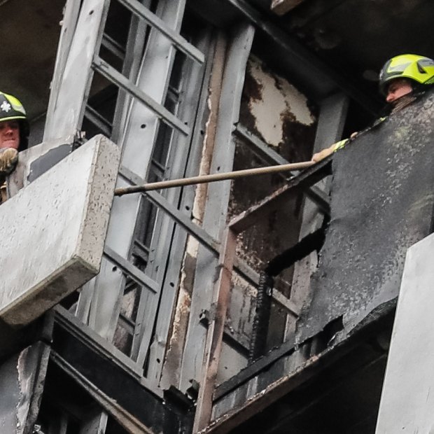 Firefighters survey the damage on the Neo 200 tower block in Melbourne's Spencer Street.