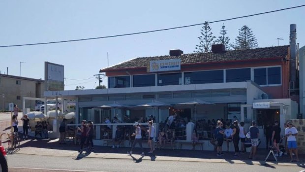 Groups of people mingle outside The Little Bay along the coast on Sunday. 