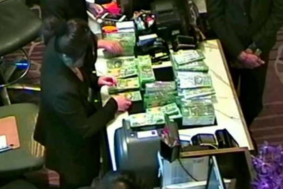 A large amount of cash being exchanged at Suncity's private gaming room at Crown Melbourne. 