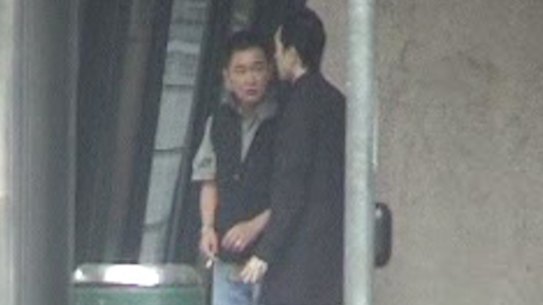 Shore party member Teng (left) with another man waiting in central Melbourne and captured on surveillance footage.
