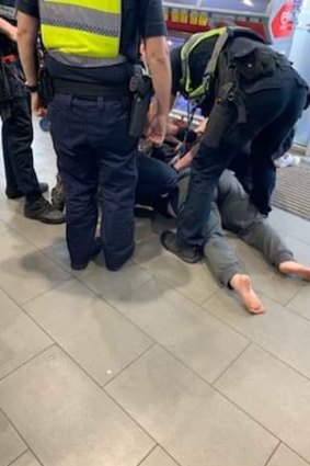 A photo of Carol being handcuffed by police. 