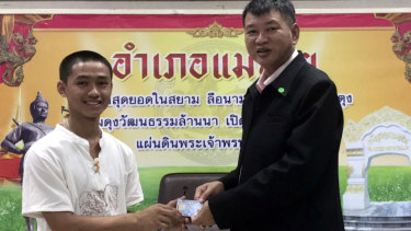 Adul "Dul" Sam-on, 14, left, receives his Thai identity card on Wednesday.