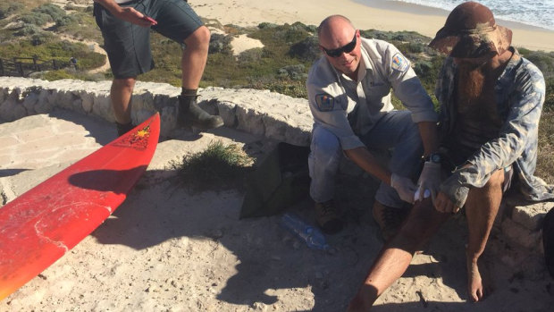 Jason Longgrass, 41, is treated by paramedics after he was bitten on his right leg at Lefties, the second shark attack in Gracetown today.