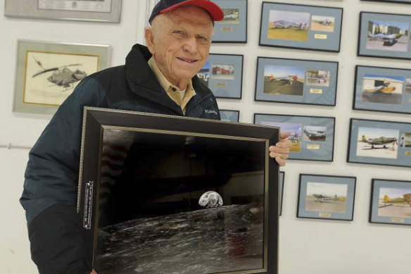 Apollo 8 Commander Frank Borman poses in Billings, Montana, with a photograph of Earth taken as his spaceship orbited the moon.