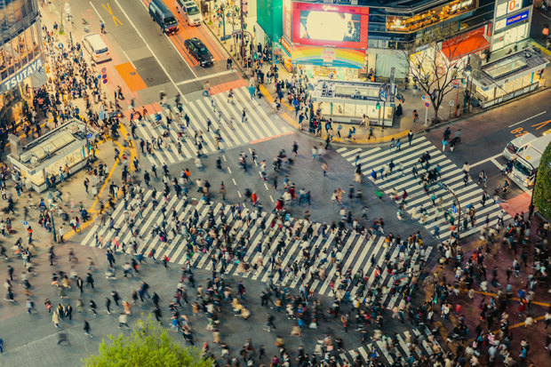 Individuals cross the road in a collective flow (kind of) in Tokyo.