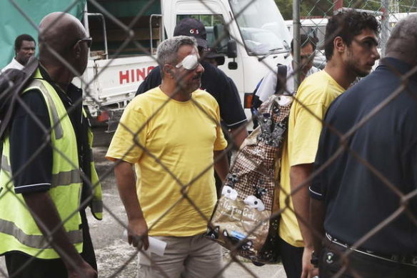 Two injured asylum seekers leave Manus Island following riots at the detention centre.