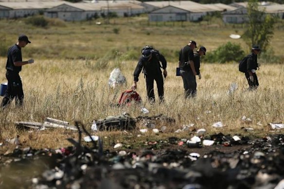 AFP officers search the MH17 crash site in Ukraine. 