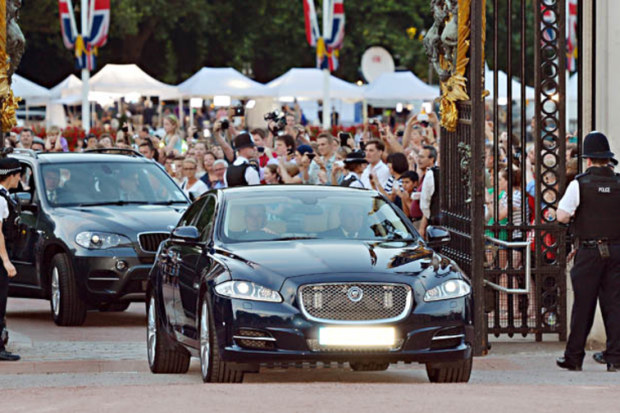 A Jaguar car is driven on into the forecourt of Buckingham Palace.