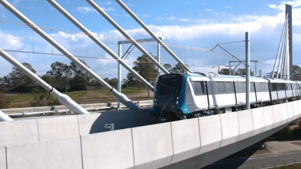 A driverless metro train passes over the new cable-stayed bridge at Rouse Hill for the first time.