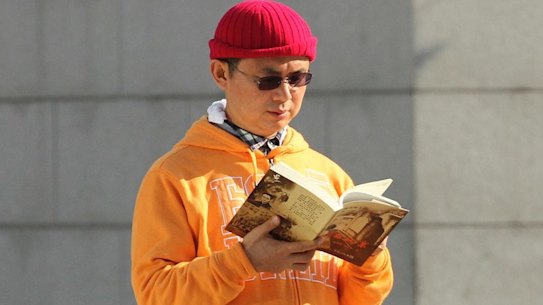 Xiao Jianhua, a Chinese-born Canadian billionaire, reads a book outside the International Finance Centre in Hong Kong.