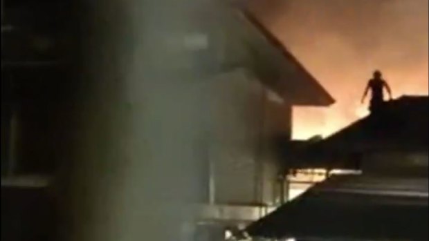 Footage posted on social media shows a Christmas Island detainee jumping on the roof of a compound on Tuesday night, with a fire in the background.