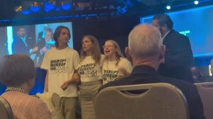 Tom Power, left, and Emma Heyink, right, protest at the Woodside AGM on April 24. Picture: 9News Perth