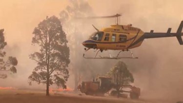 The pilot of a crashed water bombing helicopter is flown out of danger near Pechey on Wednesday.