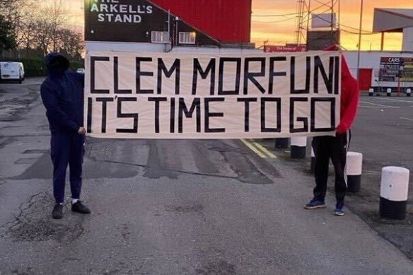 Swindon Town fans show a banner calling for Clem Morfuni’s departure.