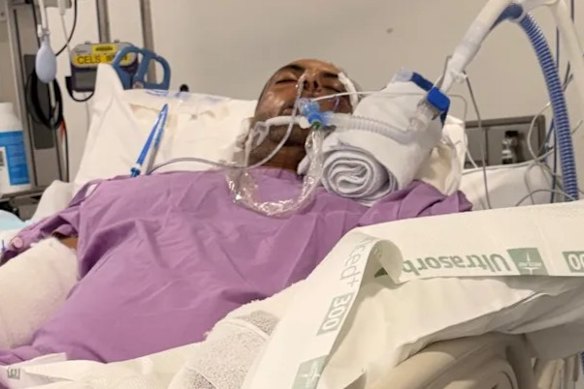 Real estate agent Ajay Malik pictured in hospital after he was attacked by two dogs while jogging in Chermside, in Brisbane’s north.