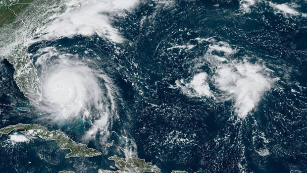 Hurricane Dorian, left, churning over the Bahamas.