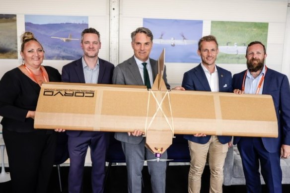 Defence Minister Richard Marles (centre) with SYPAQ team members and one of the cardboard drones.
