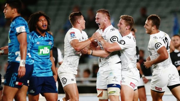 Blitz: The Sharks celebrate another try as they put the Blues to the sword.