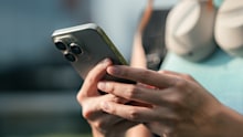 Gen Z woman scrolls on her smartphone, eyes locked on a viral video trending on her for you page, fully immersed in pop culture, internet humor, and the fast-paced world of short-form content