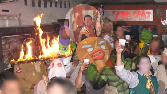 Ben Roberts-Smith, highlighted, back left, smiles and pumps his fist as a soldier in a Ku Klux Klan outfit burns a cross.