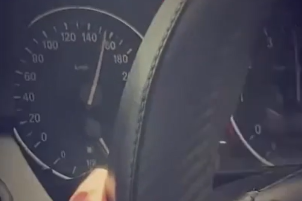 This screenshot taken from a TikTok video shows a car being driven at speed. The camera zooms out to show the BMW is being driven by a young man.