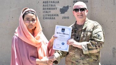In this undated photo, Zainab Azizi receives a Certificate of Appreciation from a US Army member.