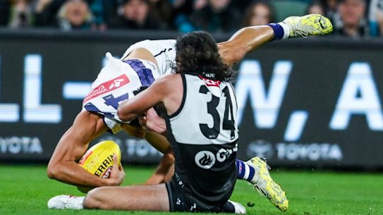 Bailey Banfield gets caught holding the ball by Lachie Jones.