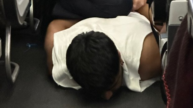 ‘What a bloody flight!’ Passenger pinned down by staff onboard Qantas flight