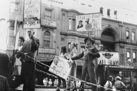 Tasman Dotti (second from left) on an Australian Aboriginal League float in the 1947 May Day procession, holding a sign declaring “Burn our Welfare Boards”.