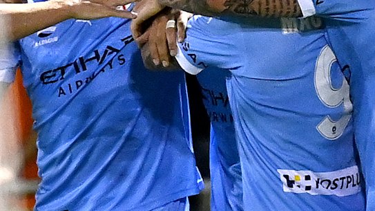 Connor Metcalfe is mobbed by his Melbourne City teammates.