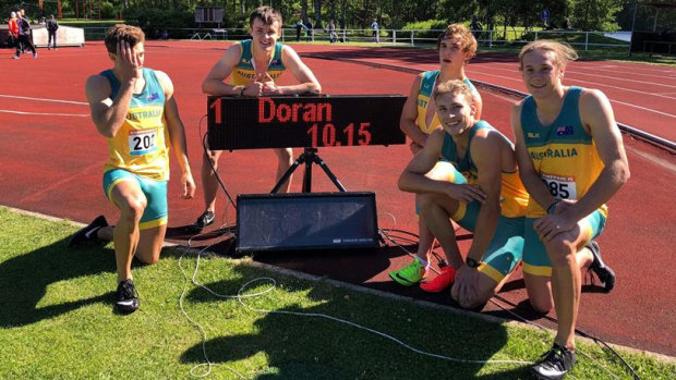 Teen sensation Jake Doran poses (on the clock) with his 100m Australian record sprint time, and his team in Finland.