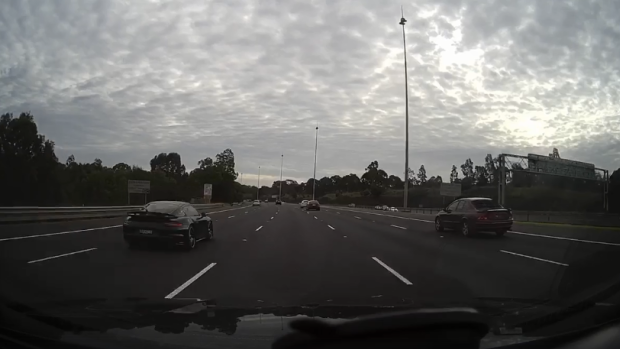 A black Porsche (left) can be seen in the video speeding down the Eastern freeway. 