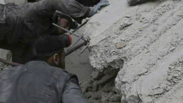 A member of the Syrian Civil Defence group, searches for victims under the rubble of a destroyed house attacked by Syrian government forces in February.