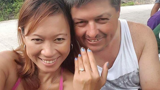 Neil Hawkins poses with a woman displaying a ring on her finger. 
