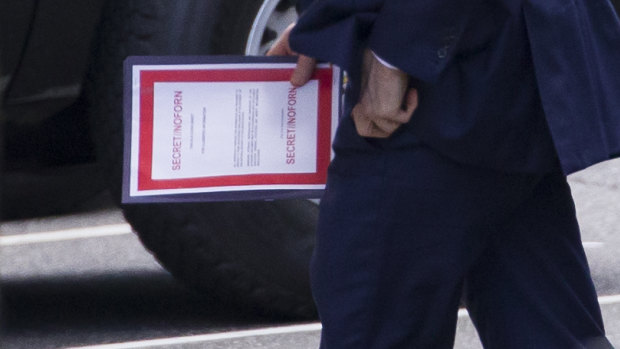 Outgoing acting US Defence Secretary Patrick Shanahan carries a document labelled secret as he arrives for a meeting with President Donald Trump about Iran at the White House on Thursday.