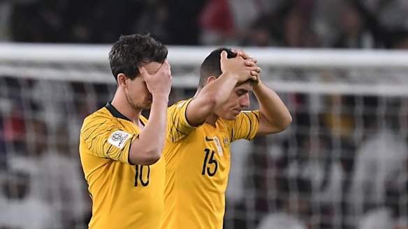 Hollow feeling: Chris Ikonomidis and Robbie Kruse hold their heads after losing 1-0 to United Arab Emirates.