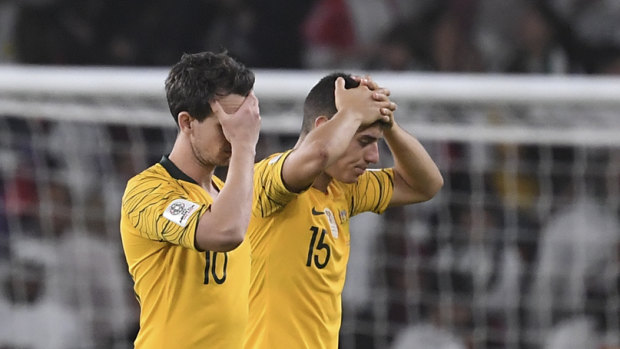 Hollow feeling: Chris Ikonomidis and Robbie Kruse hold their heads after losing 1-0 to United Arab Emirates.