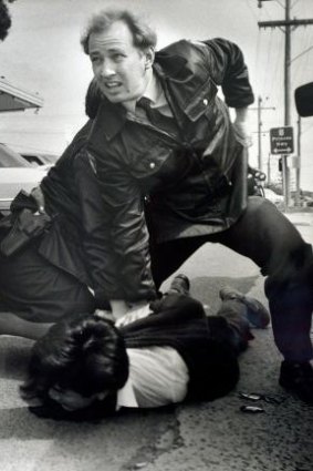 Constable Glenn Pullin arrests a man outside the rollerskating rink in Noble Park in 1992.