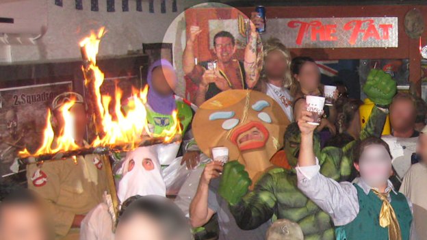 Ben Roberts-Smith, highlighted, back left, smiles and pumps his fist as a soldier in a Ku Klux Klan outfit burns a cross.
